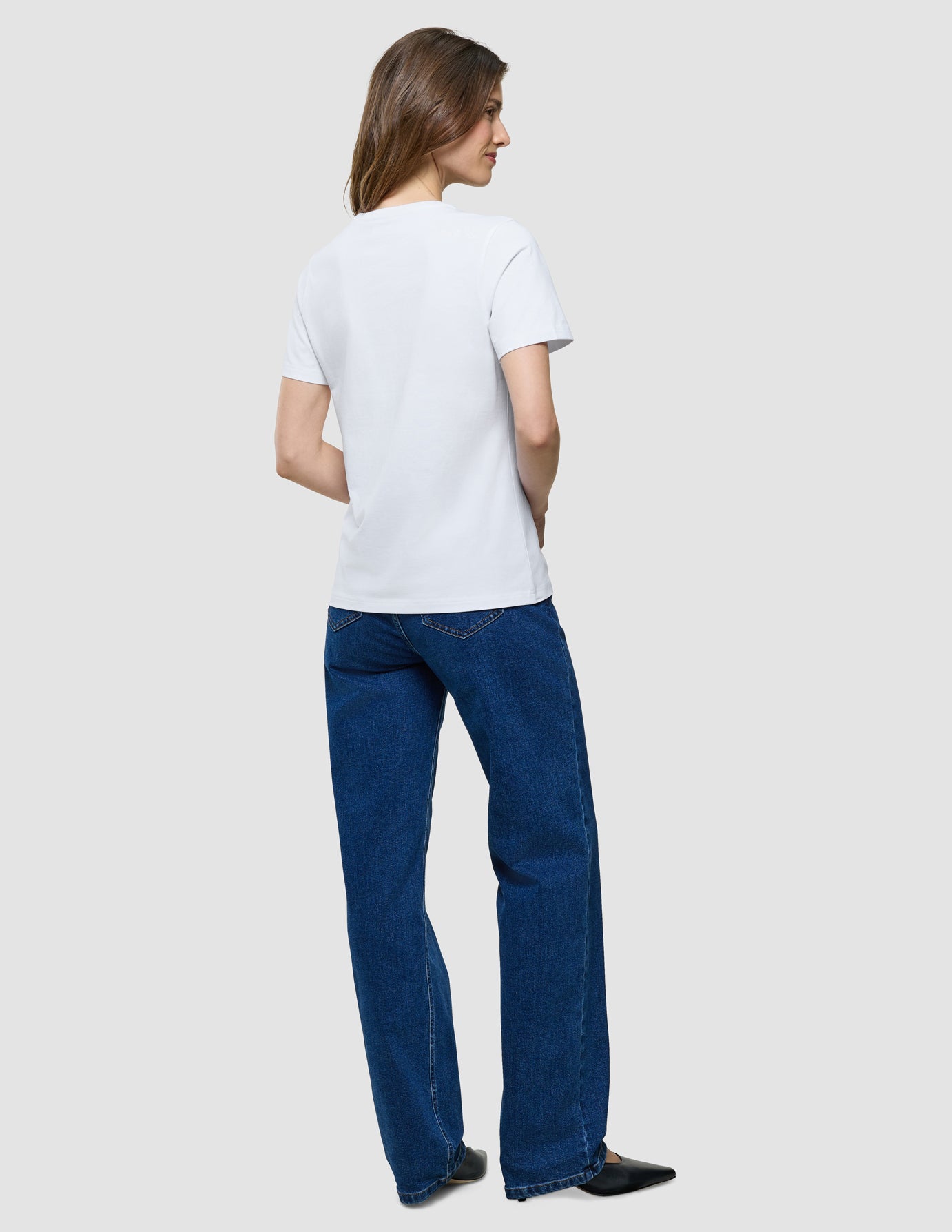Supima T-Shirt i White, helfigur bagfra viser kvinde i hvid t-shirt og blå jeans.